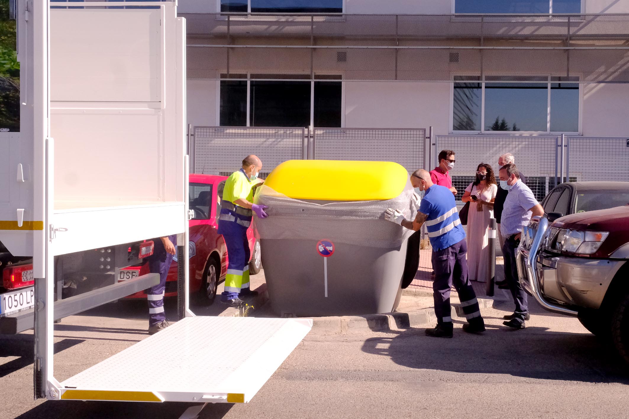 Colocación de Contenedores de Reciclaje en Polígono Industrial - Imagen de dos operarios colocando el contenedor amarillo.
