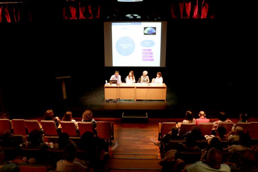Conferencia con Motivo de Día Mundial del Alzehimer - Imagen general del público asistente y mesa de conferenciantes.