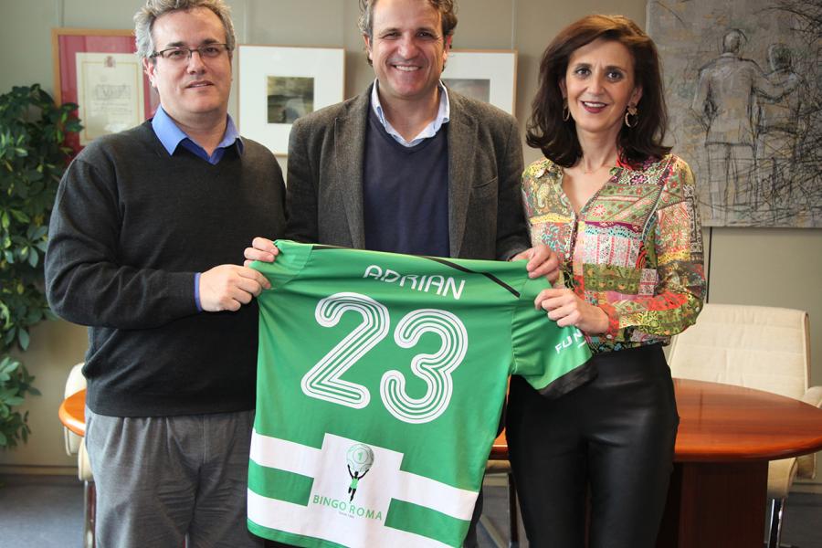 Firmantes posan tras la firma con la camiseta patrocinada