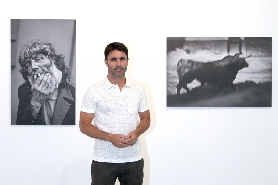 Fotógrafo Aitor Lara, posando con dos de sus fotos. 