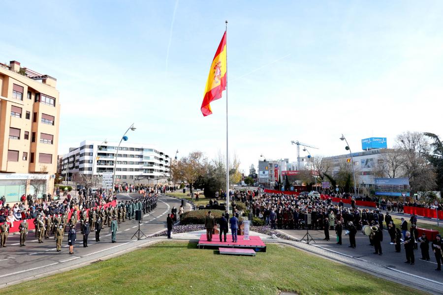Bandera ondeando en lo alto del mástil con edificio al fondo