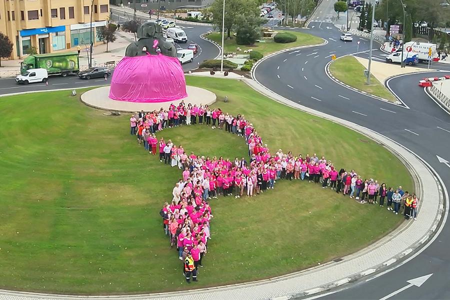 Menina con falda rosa y lazo humano con motivo del Día Mundial contra el Cáncer de Mama