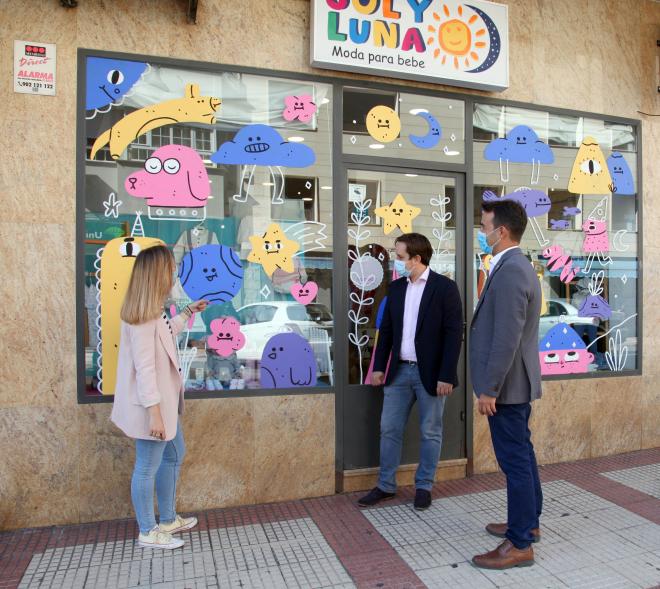 Delegación municipal observando un escaparate