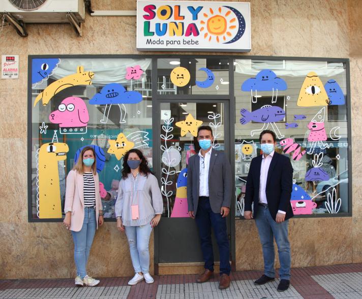 Delegación municipal posando ante un escaparate