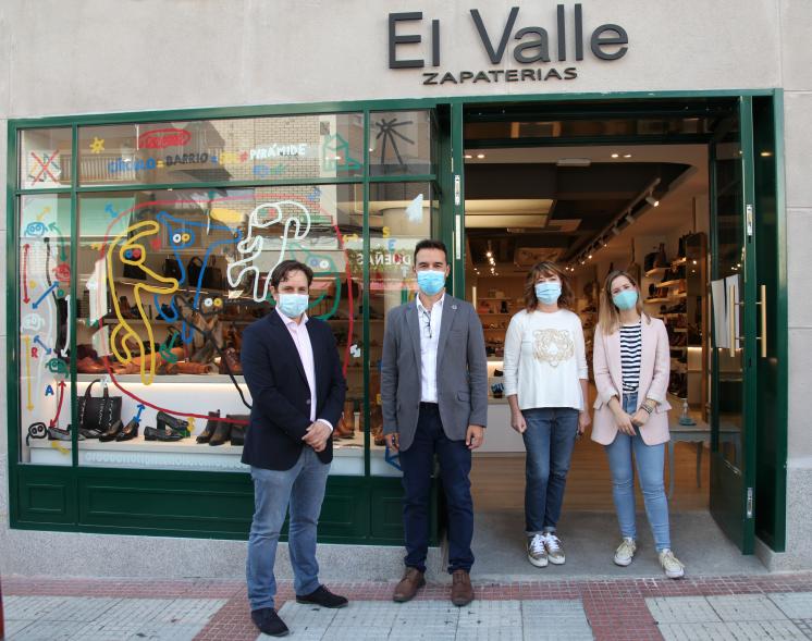 Delegación municipal posando ante un escaparate