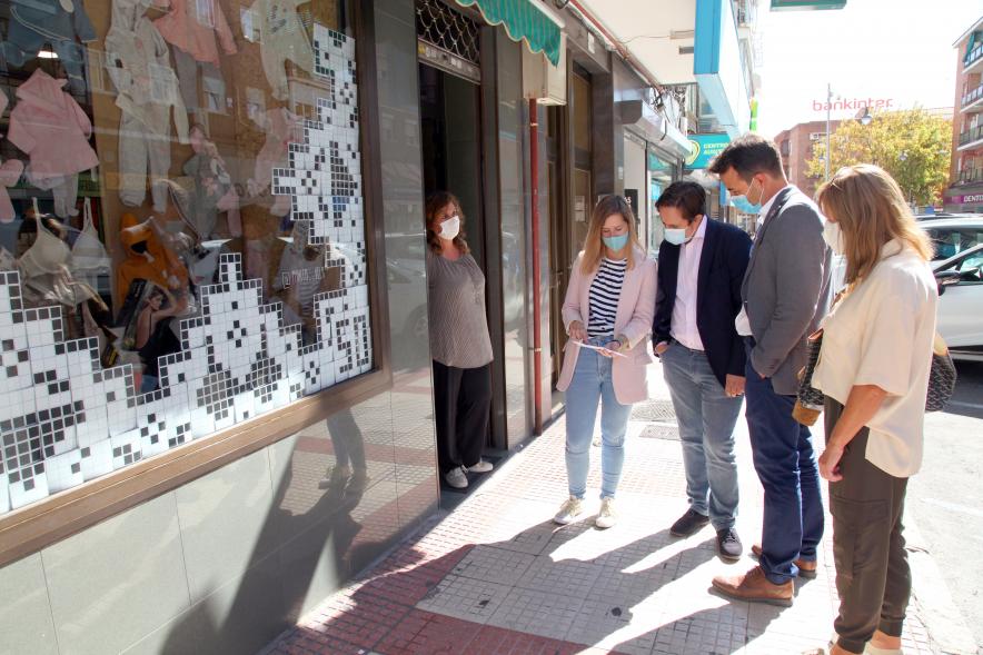 Delegación municipal observando un escaparate