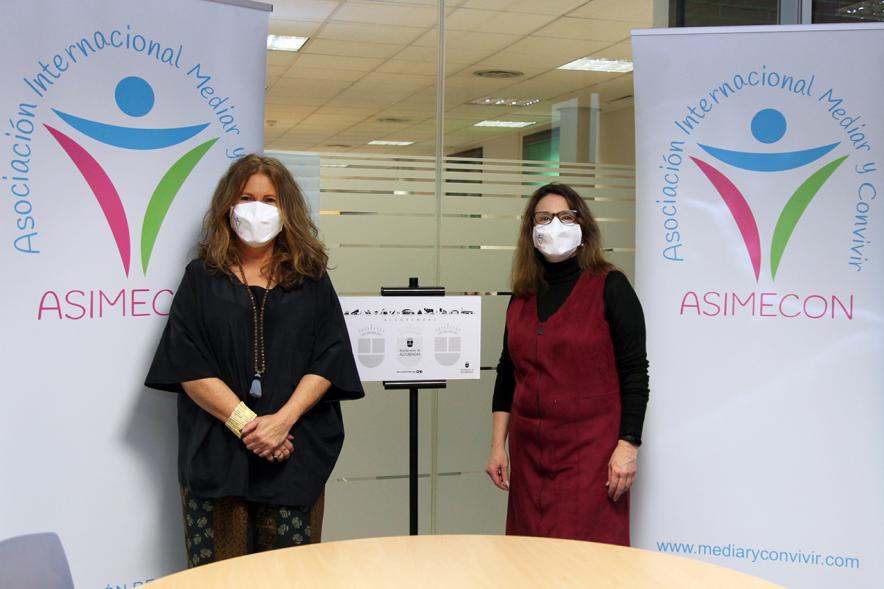 II Jornadas de Mediación Ciudad de Alcobendas -  Imagen de dos participantes con mascarilla junto al cartel de la jornada.