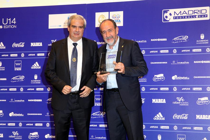 Presentación del Torneo Madrid Football Cup U-14 - imagen de dos personalidades asistentes al acto posando en el photocall, una de ellas con una placa homenaje de la mano.