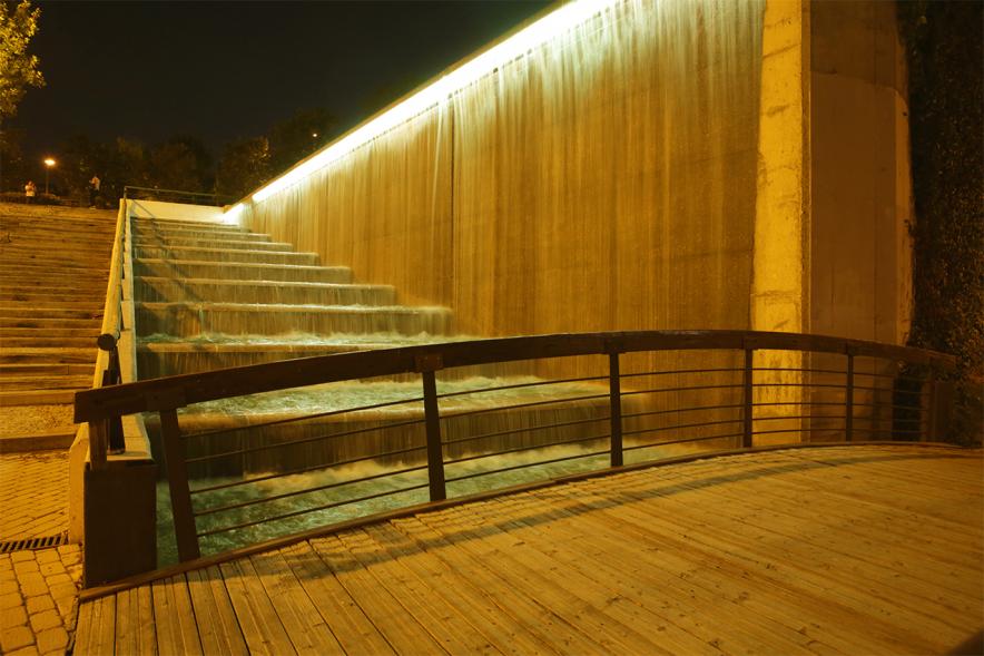 Campaña Mundial de sensibilización sobre el cáncer infantil "Enciende el oro/Enciende la esperanza". Iluminación cascada del Parque Valdelasfuentes -  Imagen parcial de la cascada iluminada con luces doradas.