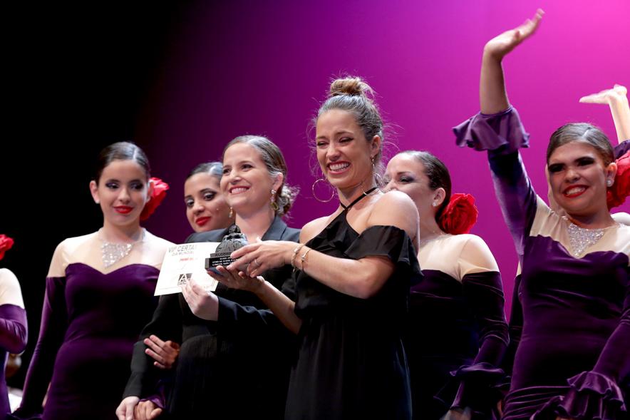 VIIº Certamen Día Mundial de la Danza ADAE - Imagen de uno de los grupos de danza participantes recibiendo un trofeo que le da una autoridad asistente al evento.
