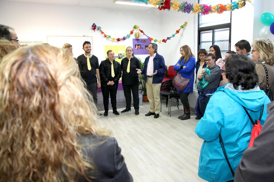Entrega Local Asociación ADILAS - Imagen del alcalde García de Vinuesa  y miembros de la asociación Adilas posando junto al grupo musical de miembros de la asociación que acaba de actuar.