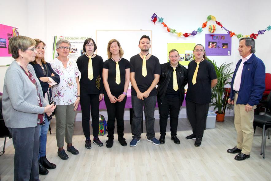 Entrega Local Asociación ADILAS - Imagen del alcalde García de Vinuesa  y miembros de la asociación Adilas posando junto al grupo musical de miembros de la asociación que acaba de actuar.