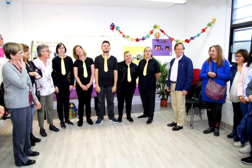 Entrega Local Asociación ADILAS - Imagen del alcalde García de Vinuesa  y miembros de la asociación Adilas posando junto al grupo musical de miembros de la asociación que acaba de actuar.