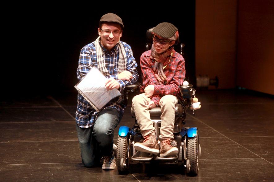Presentación Calendario APAMA 2019 - Imagen del escenario con un niño en silla de ruedas con su padre.