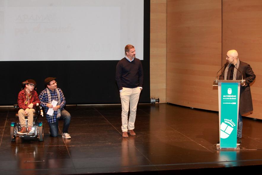 Presentación Calendario APAMA 2019 - Imagen del escenario con un niño asociado a APAMA con su padre y dos representantes municipales.