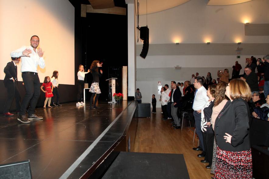 Presentación Calendario APAMA 2020 - Imagen de personas en el escenario haciendo un baile que el público asistente también trata de hacer.