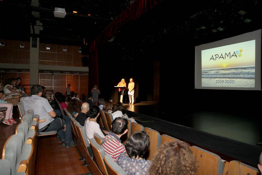 Presentación Curso Escolar 2019-20 APAMA - Imagen lateral del escenario con las representantes de APAMA y  el anfiteatro completo.