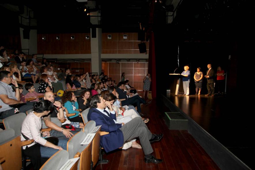 Presentación Curso Escolar 2019-20 APAMA - Imagen lateral del escenario con las representantes de APAMA y  el anfiteatro completo.