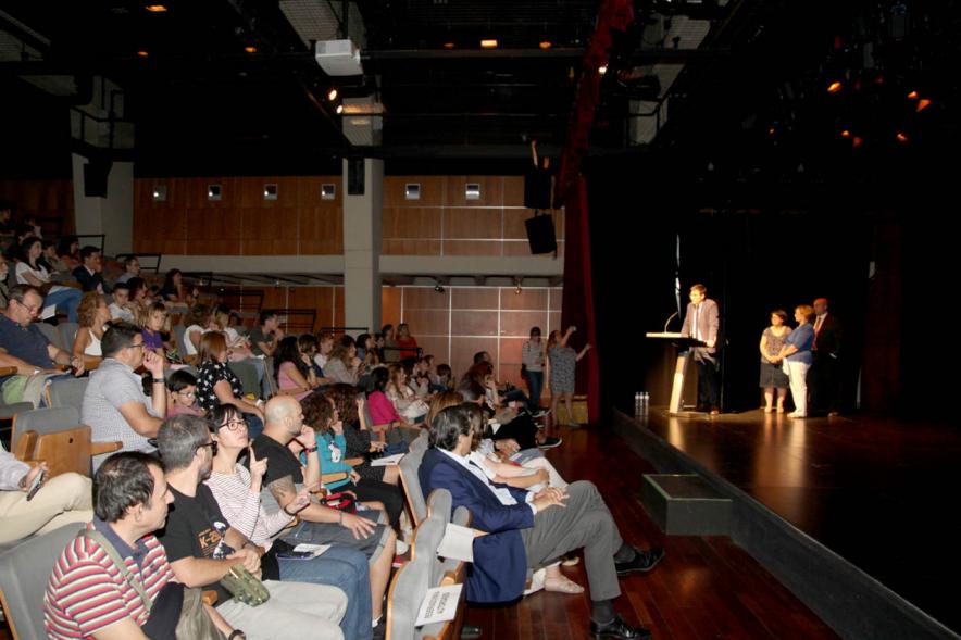 Presentación Curso Escolar 2019-20 APAMA - Imagen lateral de la presentación parte del público y  el escenario con los representantes de APAMA.