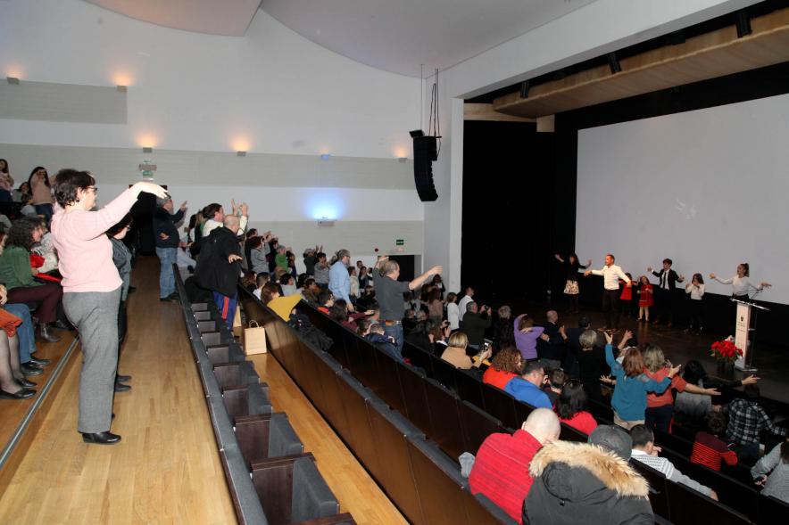 Presentación Calendario APAMA 2020 - Imagen de personas en el escenario haciendo un baile que el público asistente que también lo trata de hacer.