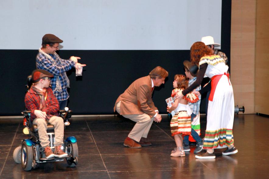 Presentación Calendario APAMA 2019 -  Plano del escenario  con un niño en silla de ruedas, su padre, el alcalde García de Vinuesa y varios asociados.