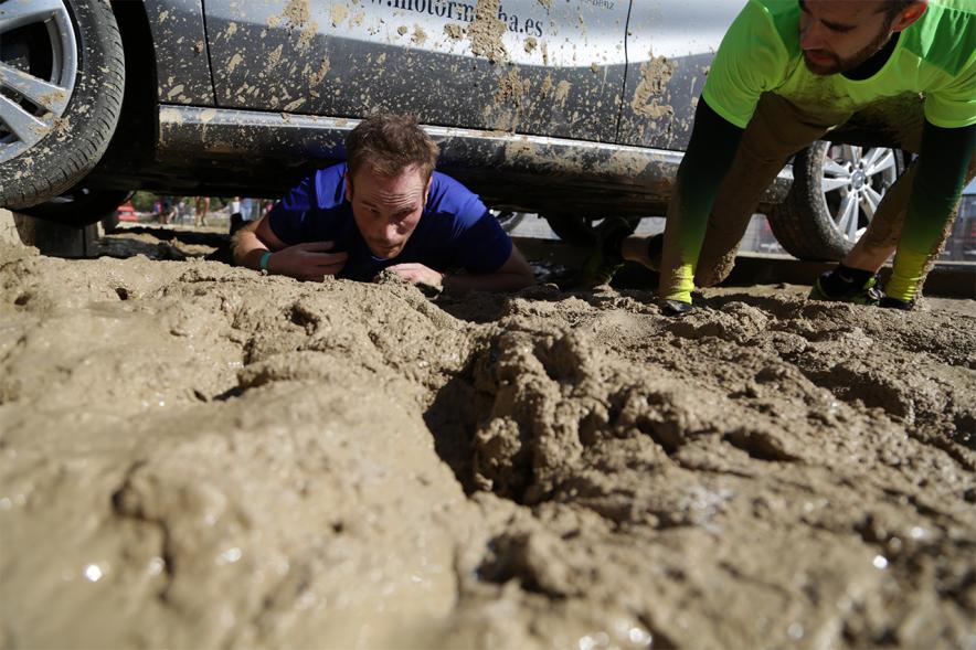 Gladiator Race - Un participante reptando sobre el barro.