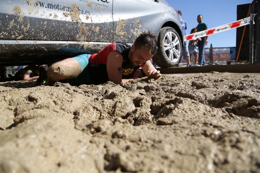 Gladiator Race - Un participante reptando sobre el barro.