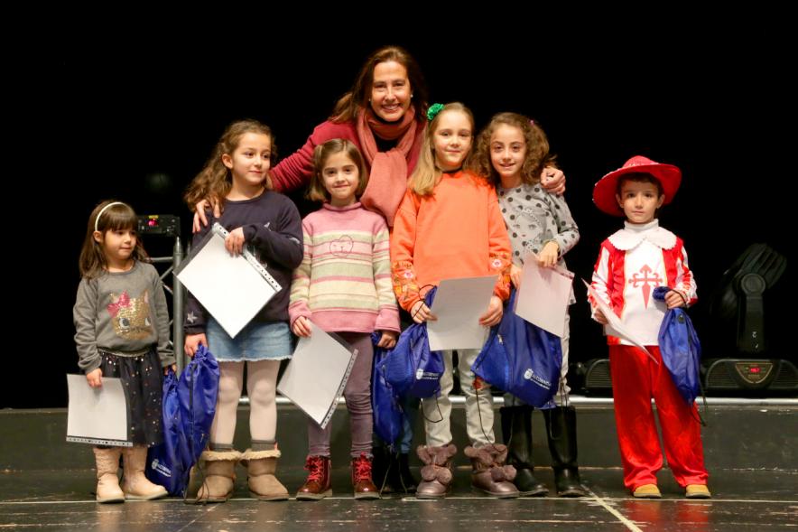 Entrega Premios del Concurso Ilumina Alcobendas 2018 - Imagen de unos niños en el escenario con unos diplomas y unos regalos.