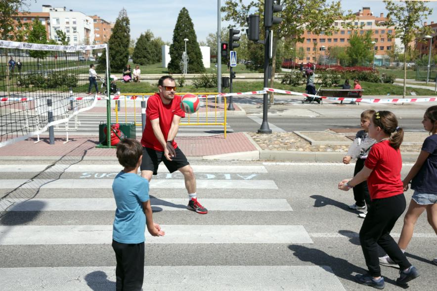 Niños jugando al voleibol con monitor