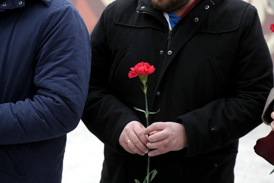 Ofrenda Floral en Memoria de los Abogados de Atocha - Imagen de una mano con el clavel rojo.