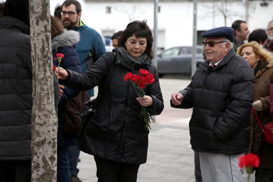 Ofrenda Floral en Memoria de los Abogados de Atocha - Imagen de personas asistentes al acto, todas con un clavel rojo en la mano.