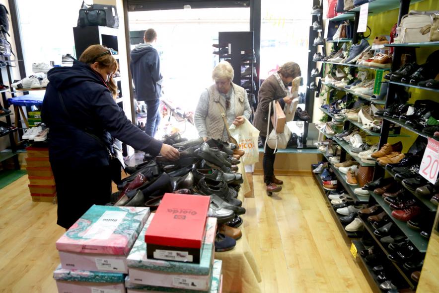 Visita Tiendas Alcostock 2019 - Imagen de unos clientes mirando zapatos en el interior de un comercio participante en la feria.