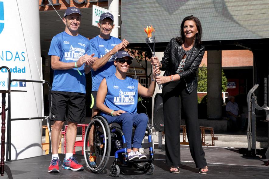 Carrera de la Antorcha Olímpica - Imagen de una persona entregando llama olímpica aun atleta paralímpico.