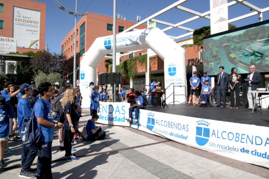Carrera de la Antorcha Olímpica - Imagen de personas en el escenario y una de ellas dirigiéndose al público.