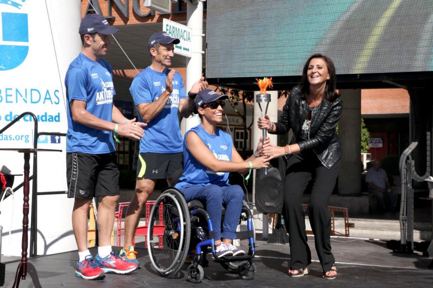Carrera de la Antorcha Olímpica - Imagen de una persona entregando llama olímpica aun atleta paralímpico.