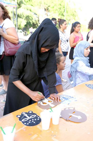 Participante pintando mascaras. Fiesta del ArcoIris 2019 