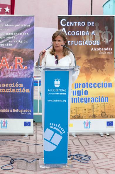 Celebración del Día del Arcoiris 2018 - Primer plano de la concejal con los carteles del acto.