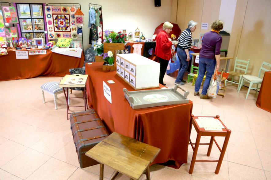Exposición Asociación de Artesanas de Alcobendas -  Panorámica de la exposición con todos los productos artesano  y varios visitantes.