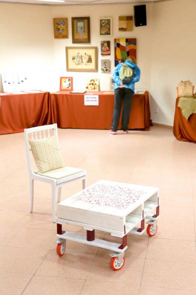 Exposición Asociación de Artesanas de Alcobendas - Primer plano de una mesa y una silla con ruedas. 
