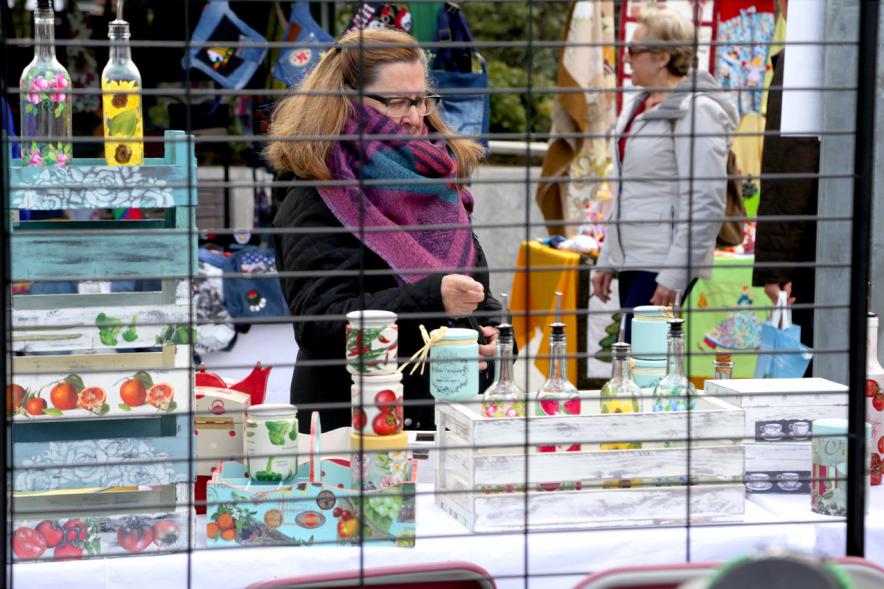 Paseo del Arte y de la Artesanía - Días Europeos de la Artesanía - Exposiciones de Artesanía Tradicional en la Plaza Mayor - Imagen de una persona mirando los productos de uno de los stand.