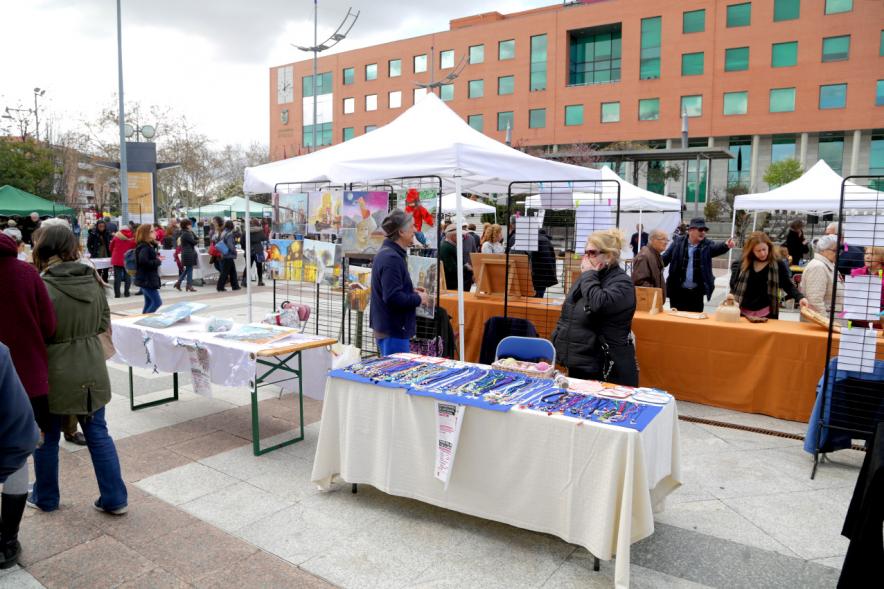 Paseo del Arte y de la Artesanía - Días Europeos de la Artesanía - Exposiciones de Artesanía Tradicional en la Plaza Mayor - Imagen de una persona mirando los productos de uno de los stand.