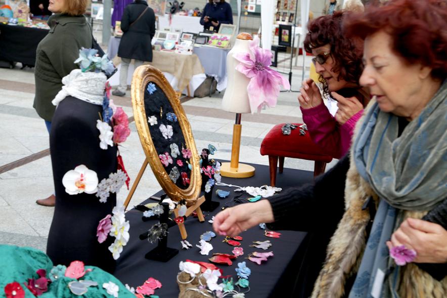 Paseo del Arte y de la Artesanía - Días Europeos de la Artesanía - Exposiciones de Artesanía Tradicional en la Plaza Mayor - Imagen de una persona mirando los productos de uno de los stand.