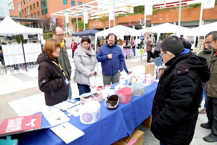 Paseo del Arte y de la Artesanía - Días Europeos de la Artesanía - Exposiciones de Artesanía Tradicional en la Plaza Mayor - Imagen de unas personas mirando los productos de uno de los stand.