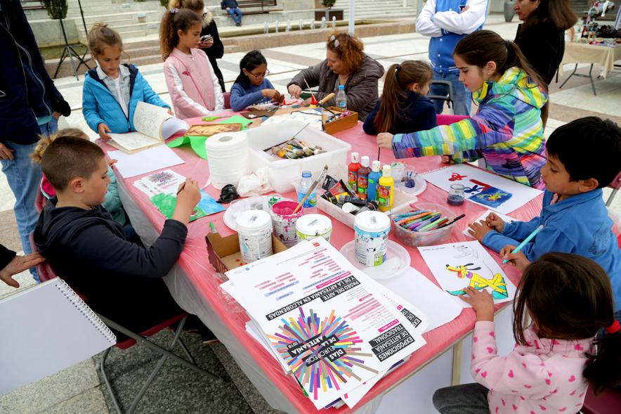 Paseo del Arte y de la Artesanía - Días Europeos de la Artesanía - Exposiciones de Artesanía Tradicional en la Plaza Mayor - Imagen de unos niños haciendo manualidades con una monitora.
