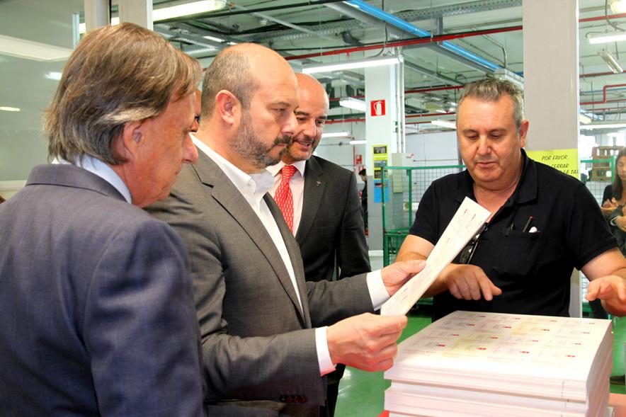 Visita Vicepresidente de la CAM a la Sede del BOCM - Imagen del Vicepresidente hojeando una prueba del BOCM junto al alcalde García de Vinuesa y un trabajador.