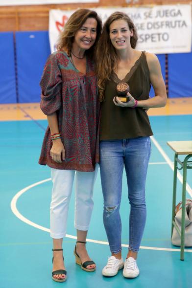 Torneo de Baloncesto XI Memorial Antonio de la Serna - Imagen de una persona recibiendo un trofeo de manos de una autoridad asistente al encuentro.