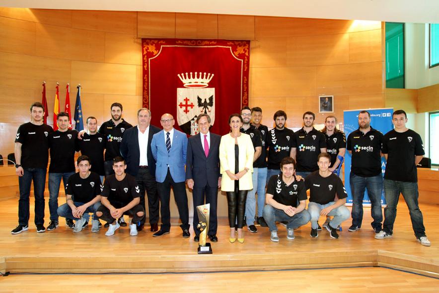 Recepción por los Ascensos del Equipo Femenino y Masculino de Balonmano - Imagen del alcalde García de Vinuesa posando junto a los jugadores de balonmano y los trofeos.