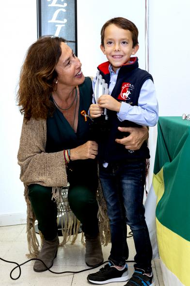 Entrega de Premios Barrio del Pilar 2018 - Imagen de un niño mostrando su trofeo posando con la persona que se lo ha entregado.