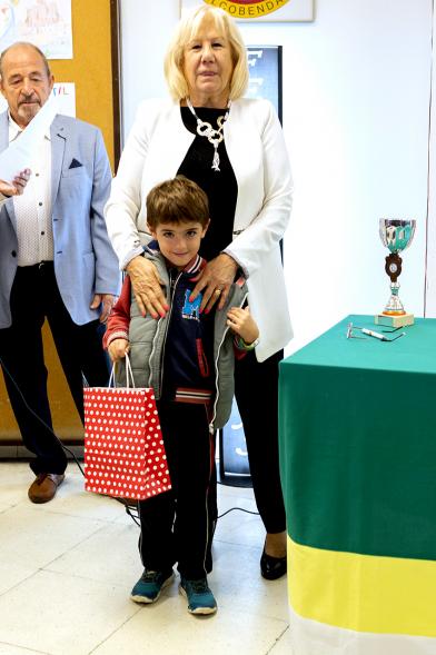 Entrega de Premios Barrio del Pilar 2018 - Imagen de un niño mostrando su regalo posando con la persona que se lo ha entregado.