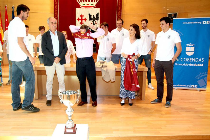 Recepción Equipo de Baloncesto por su Ascenso de Liga - Imagen del alcalde García de Vinuesa poniéndose la camiseta del equipo entregada por los jugadores.